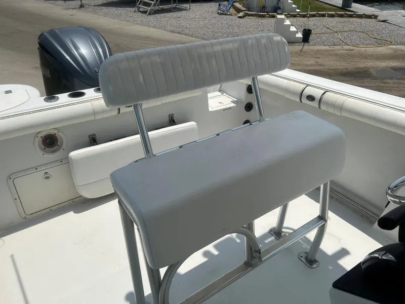 Slide: The Image of 2004 Sailfish 236 CC boat interior with white cushioned seating and console. - 19