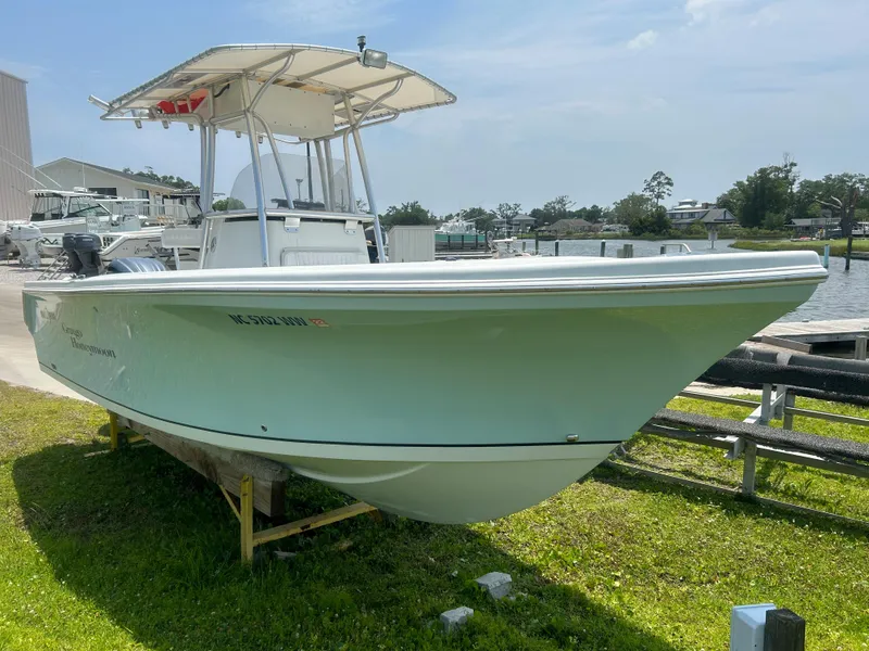 Slide: The Image of 2004 Sailfish 236 CC boat on display, docked on grass near a marina. - 5