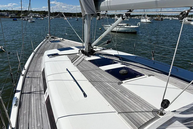 Slide: The Image of 2014 Hanse 445 sailboat deck with wooden finish, moored in a scenic harbor. - 10