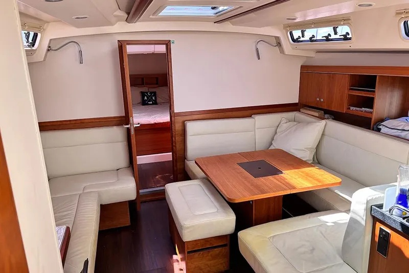 Slide: The Image of Interior of 2014 Hanse 445 yacht with cozy seating and wooden table. - 14