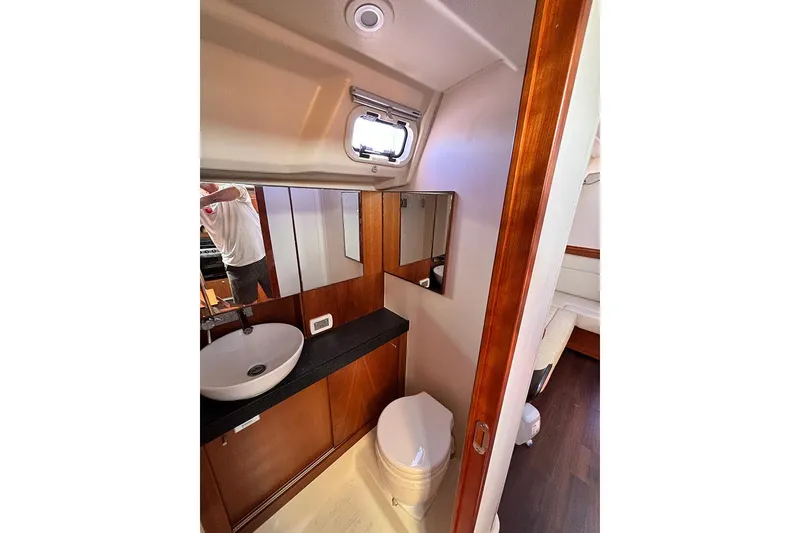 Slide: The Image of 2014 Hanse 445 yacht bathroom with modern sink, mirror, and wooden cabinetry. - 18