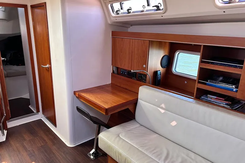Slide: The Image of Interior of 2014 Hanse 445 yacht with wooden desk, shelves, and seating area. - 19