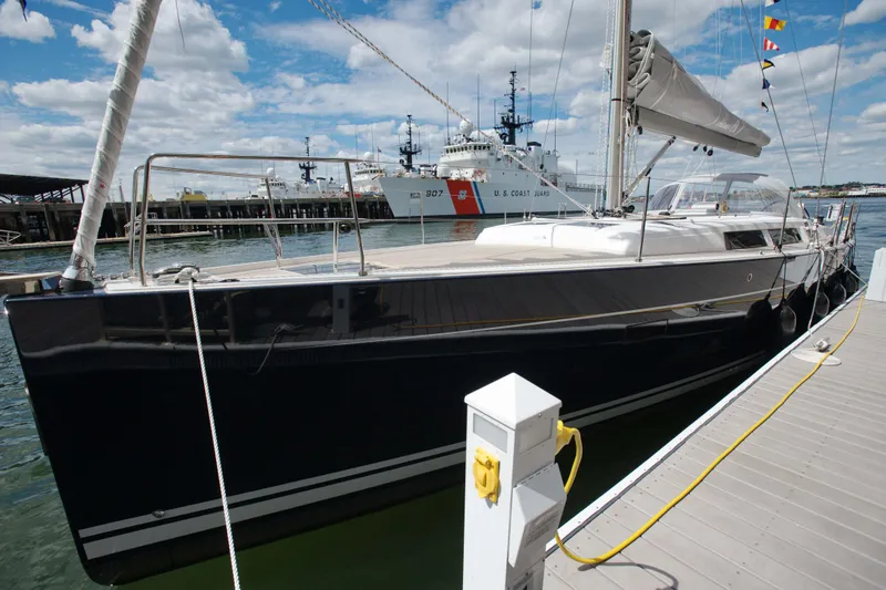 Slide: The Image of 2014 Hanse Yachts 445 sailboat docked at marina with coast guard ship in background. - 3