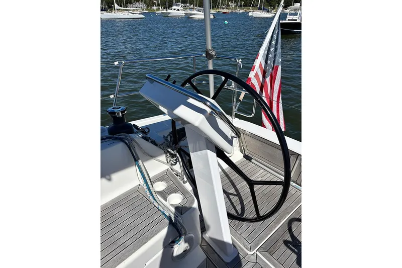 Slide: The Image of Steering wheel of 2014 Hanse 445 sailboat with American flag in marina setting. - 9
