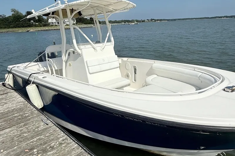 Slide: The Image of 2008 Edgewater 228CC boat docked by the water on a sunny day. - 3