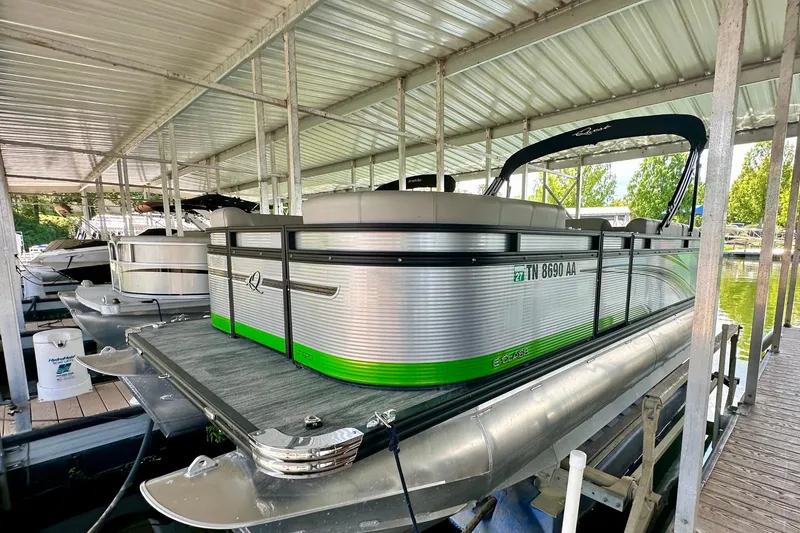 Slide: The Image of 2023 Qwest LT 820 pontoon boat docked under a covered marina. - 5
