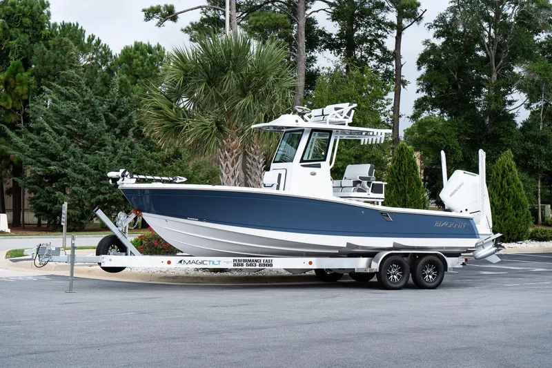 The Image of 2026 Blackfin 262 HB boat on trailer, parked outdoors with trees in background. - 1