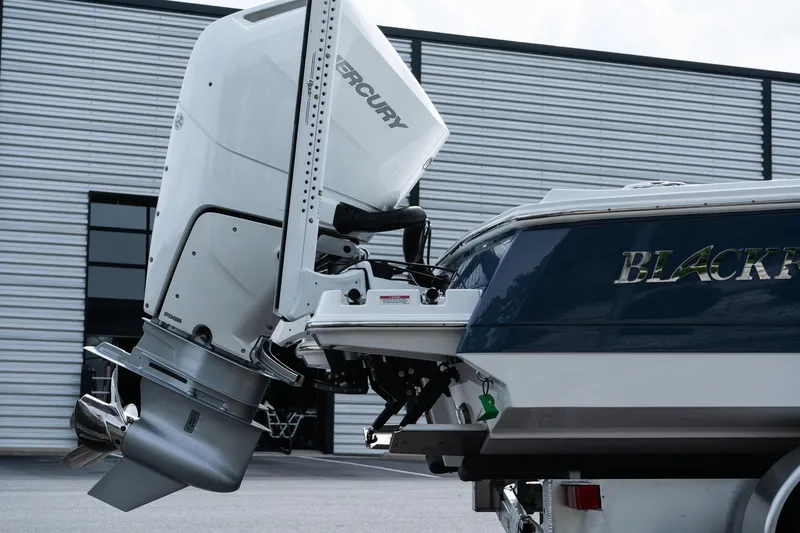 Slide: The Image of 2026 Blackfin 262 HB boat with Mercury outboard engine, docked near a modern building. - 12