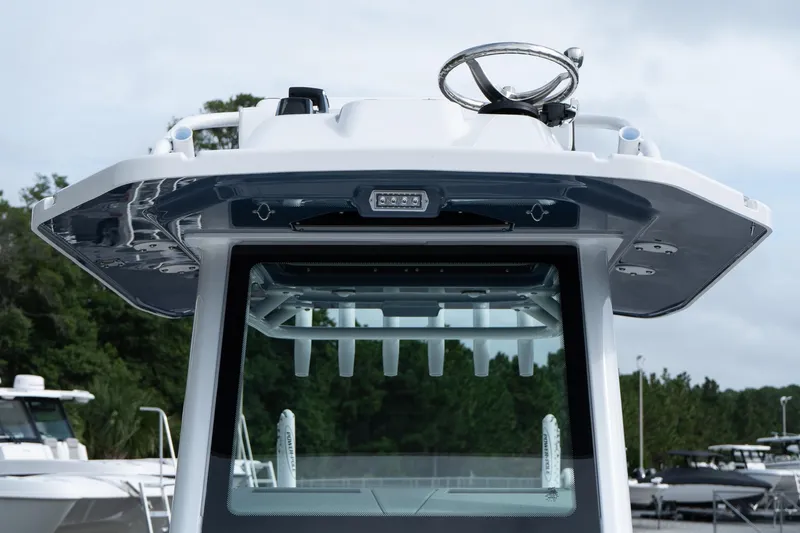Slide: The Image of 2026 Blackfin 262 HB boat helm with steering wheel, docked outdoors. - 15