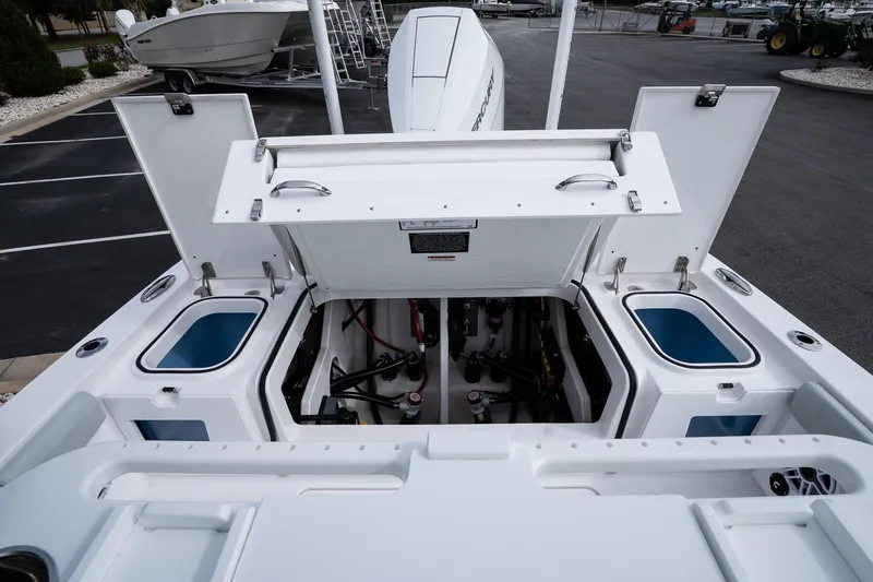 Slide: The Image of 2026 Blackfin 262 HB boat engine compartment with open hatches, showcasing storage and mechanical components. - 23