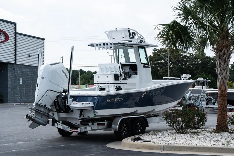 Slide: The Image of 2026 Blackfin 262 HB boat on trailer near palm tree and dealership. - 8