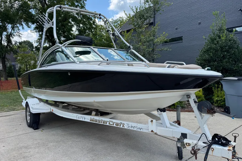 Slide: The Image of 2002 MasterCraft ProStar 209 boat on trailer, parked outdoors. - 2