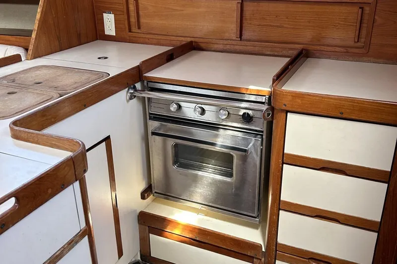 Slide: The Image of 1987 Pearson 39-2 yacht kitchen with stove, wooden cabinetry, and countertop. - 16