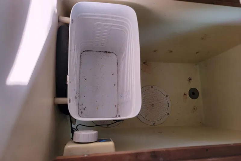 Slide: The Image of Interior of 1987 Pearson 39-2 boat with storage compartment and white container. - 25