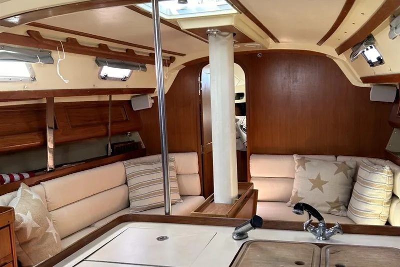 Slide: The Image of Cozy interior of 1987 Pearson 39-2 sailboat with 2016 Beta engine, featuring plush seating. - 5