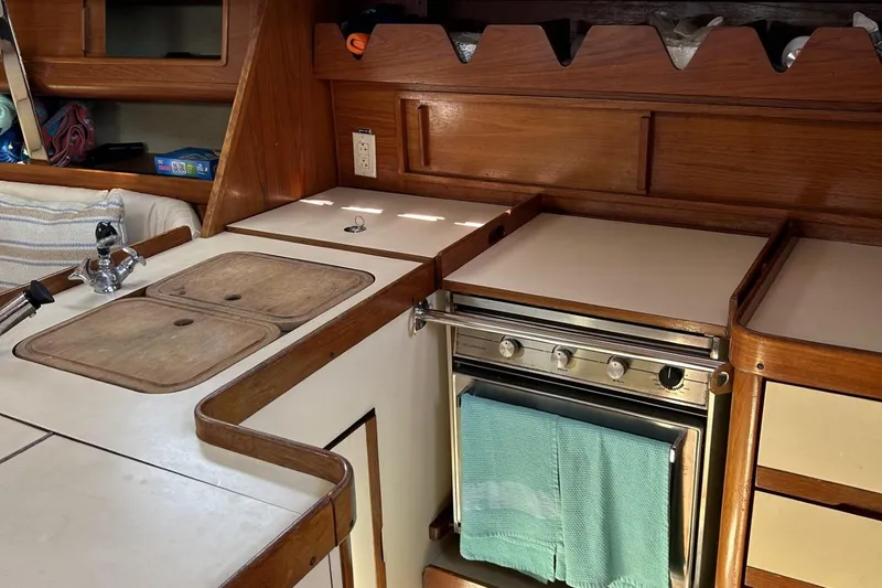 Slide: The Image of 1987 Pearson 39-2 yacht kitchen with stove, sink, and wooden cabinetry. - 7