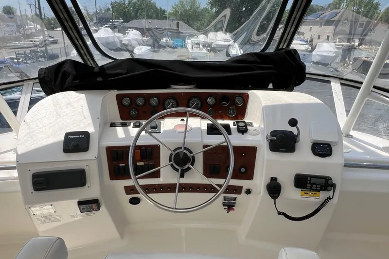 Slide: The Image of 2002 Silverton 453 Motor Yacht helm with steering wheel, gauges, and navigation equipment. - 12