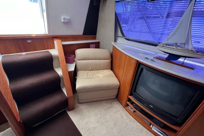 Slide: The Image of Interior of 2002 Silverton 453 Motor Yacht with TV, chair, and model sailboat. - 23
