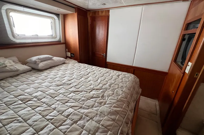 Slide: The Image of Luxurious bedroom interior of 2002 Silverton 453 Motor Yacht with cozy bedding and wooden accents. - 25