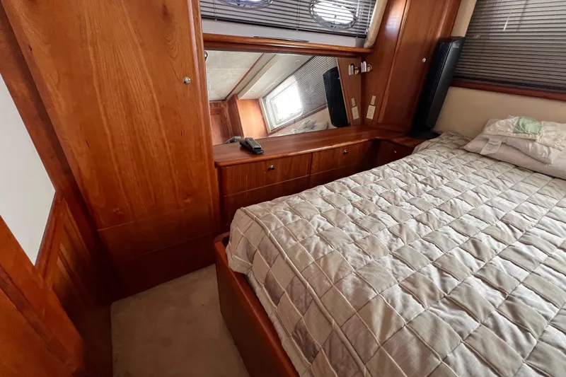 Slide: The Image of Luxurious cabin interior of 2002 Silverton 453 Motor Yacht with wood paneling and cozy bedding. - 26