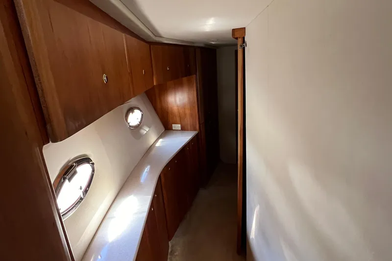 Slide: The Image of Interior hallway of 2002 Silverton 453 Motor Yacht with wooden cabinets and porthole windows. - 34