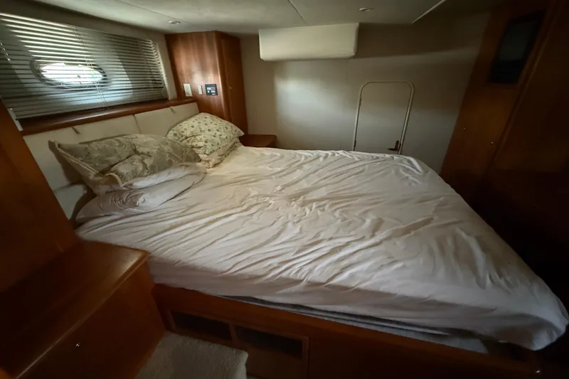 Slide: The Image of Cozy bedroom interior of 2002 Silverton 453 Motor Yacht with bed and wooden furnishings. - 38