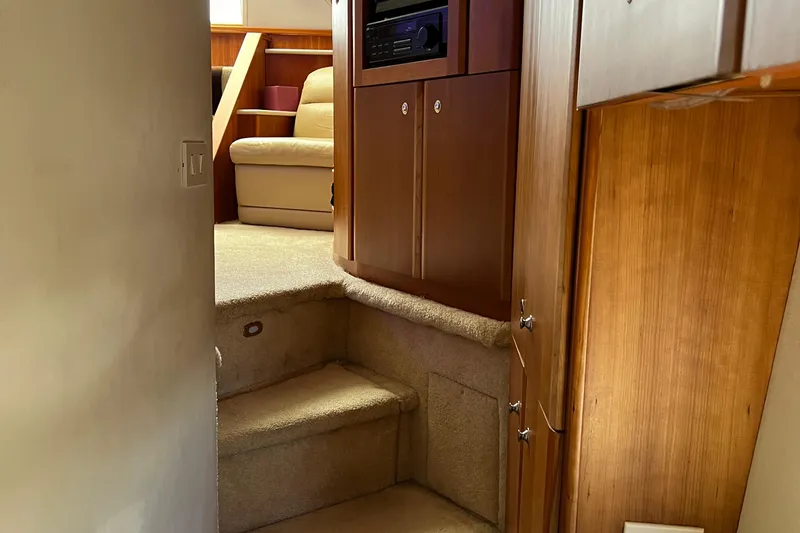 Slide: The Image of Interior view of 2002 Silverton 453 Motor Yacht, featuring carpeted stairs and wooden cabinetry. - 40