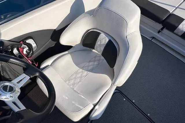 Slide: The Image of 2017 Glastron GT 205 boat interior with white and black seating and steering wheel. - 14