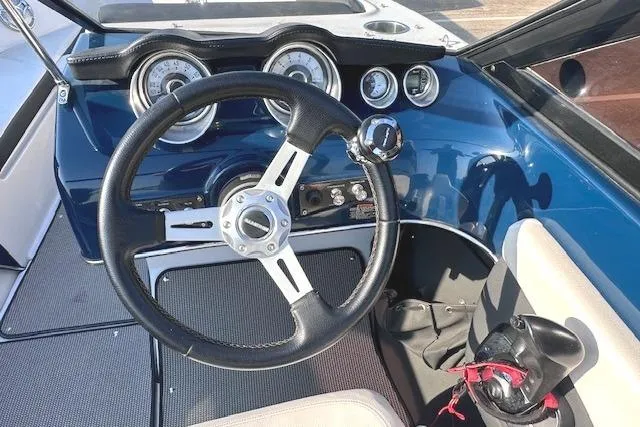 Slide: The Image of Steering wheel and dashboard of 2017 Glastron GT 205 boat, featuring gauges and controls. - 17