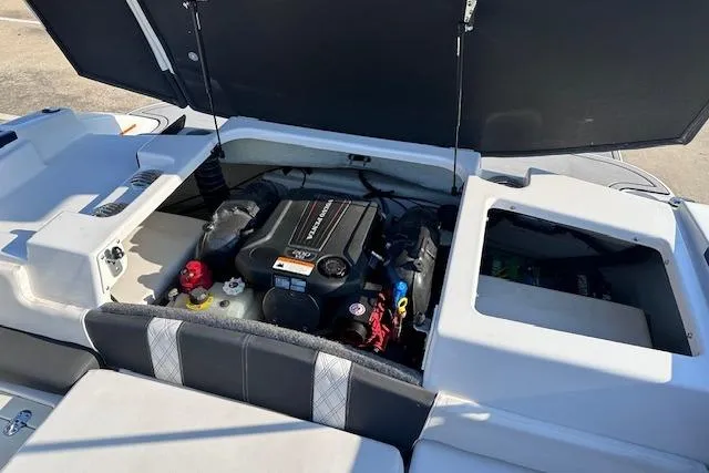 Slide: The Image of 2017 Glastron GT 205 boat engine compartment with open hatch, showcasing engine details. - 23