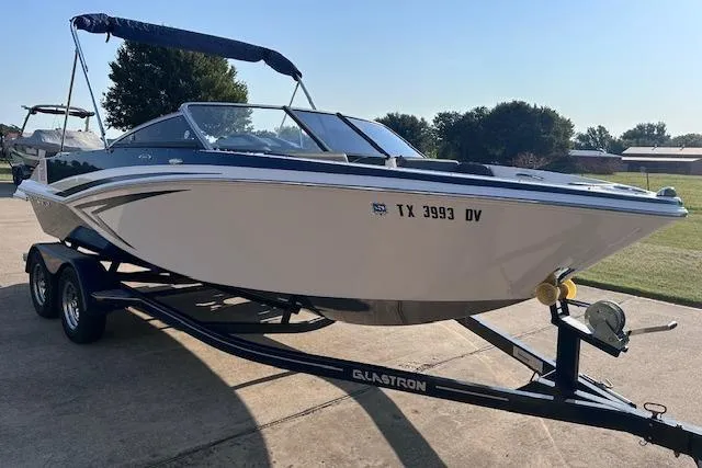 Slide: The Image of 2017 Glastron GT 205 boat on trailer, parked outdoors on a sunny day. - 4