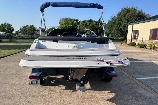 Slide: The Image of 2017 Glastron GT 205 boat with blue canopy, parked on concrete driveway. - 5