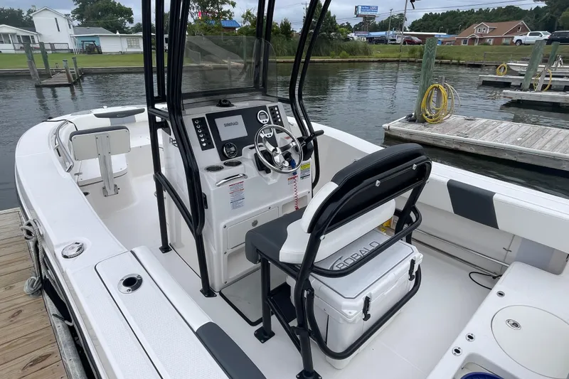 Slide: The Image of 2024 Robalo R202 Explorer boat interior at dock, featuring helm and seating. - 10