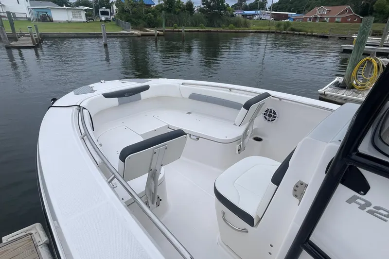 Slide: The Image of 2024 Robalo R202 Explorer boat interior with seating, docked by the water. - 13