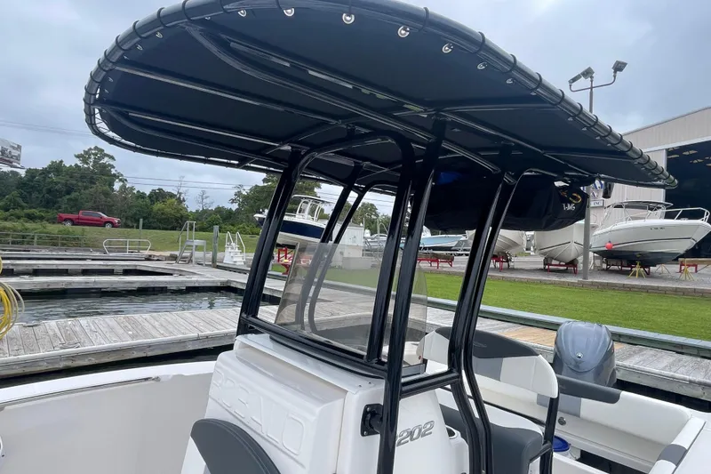 Slide: The Image of 2024 Robalo R202 Explorer boat with T-top at marina dock. - 16