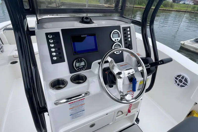 Slide: The Image of 2024 Robalo R202 Explorer boat dashboard with steering wheel and navigation controls. - 17
