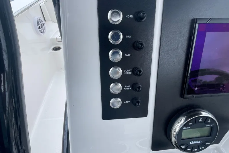 Slide: The Image of 2024 Robalo R202 Explorer dashboard with control buttons and Clarion audio system. - 18