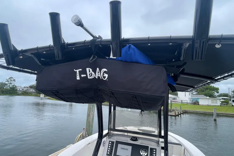 Slide: The Image of 2024 Robalo R202 Explorer boat with T-Bag storage on T-top, docked by a calm waterfront. - 28