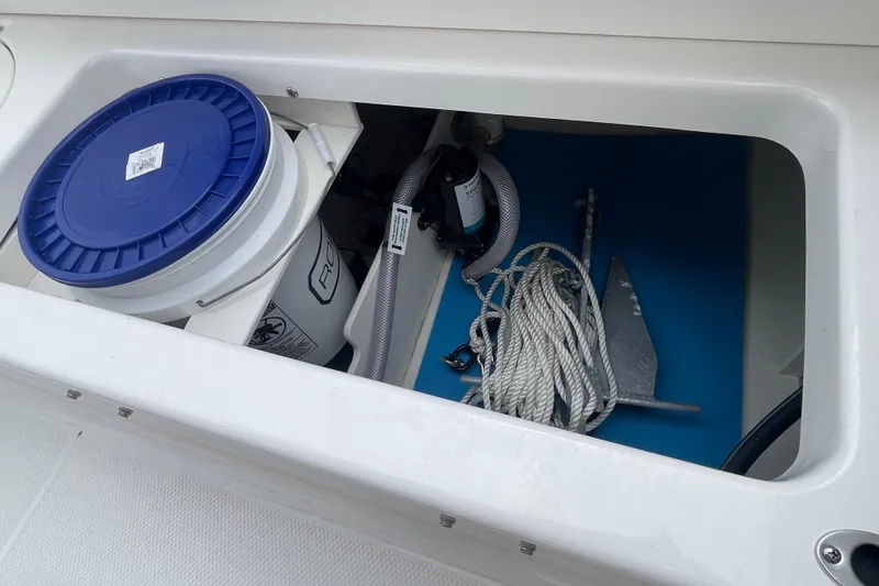 Slide: The Image of Storage compartment in 2024 Robalo R202 Explorer with bucket, rope, and anchor. - 34