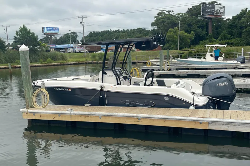 Slide: The Image of 2024 Robalo R202 Explorer boat docked with Yamaha engine, in a marina setting. - 5