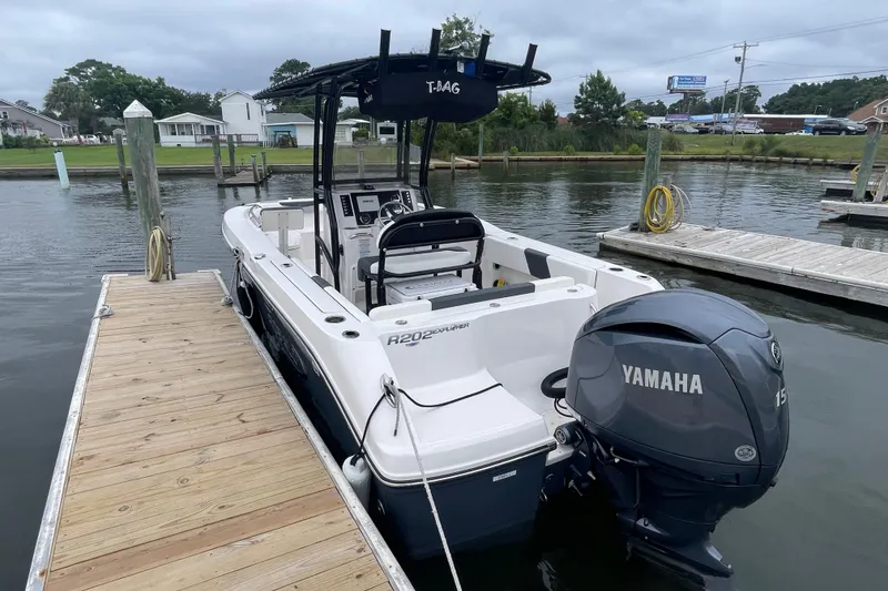 Slide: The Image of 2024 Robalo R202 Explorer boat docked with Yamaha engine, overcast sky. - 8