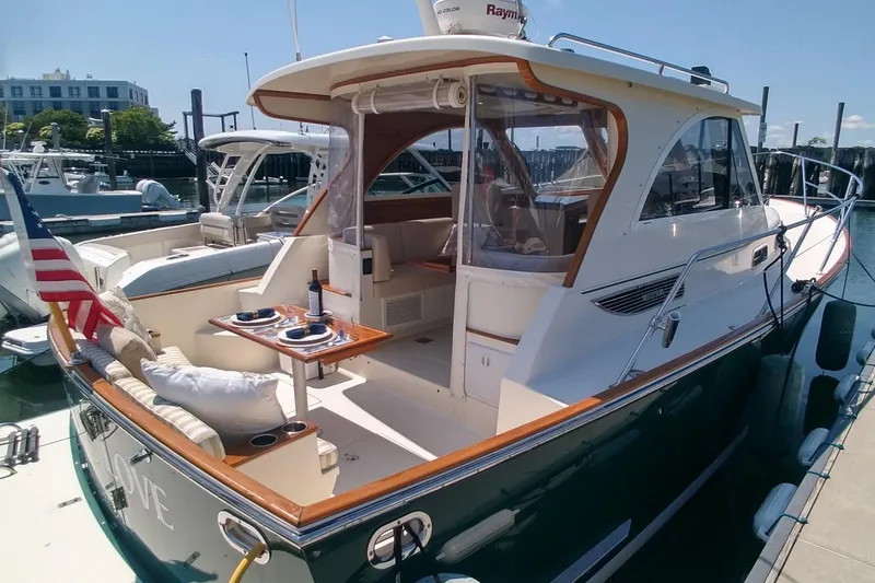 Slide: The Image of 2008 Legacy Yachts 32 docked, featuring elegant design and outdoor dining setup. - 11