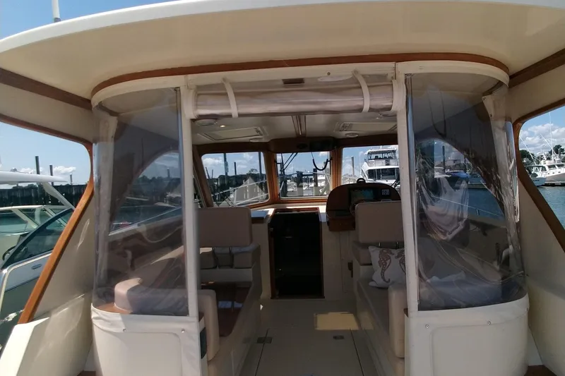 Slide: The Image of 2008 Legacy Yachts 32 interior with clear enclosures, docked at a marina. - 15