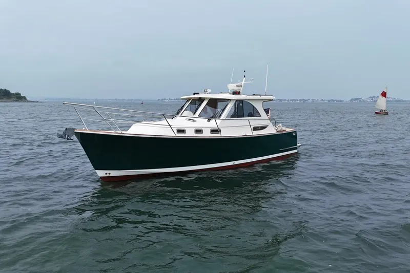 Slide: The Image of 2008 Legacy Yachts 32 cruising on calm waters with distant sailboat. - 2