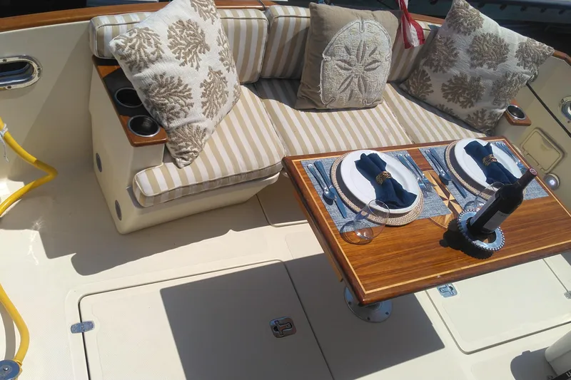 Slide: The Image of Elegant dining setup on 2008 Legacy Yachts 32, featuring striped cushions and decorative pillows. - 21