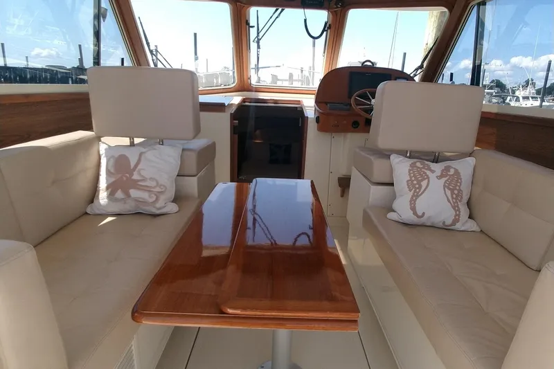 Slide: The Image of Interior of 2008 Legacy Yachts 32 with plush seating and nautical-themed pillows. - 23