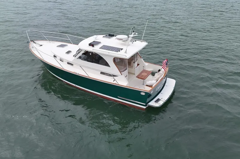 Slide: The Image of 2008 Legacy Yachts 32 cruising on open water, featuring a sleek design and American flag. - 3