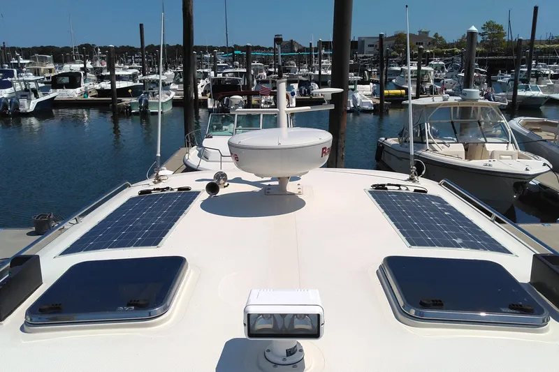 Slide: The Image of 2008 Legacy Yachts 32 docked, featuring solar panels and radar, surrounded by other boats. - 30