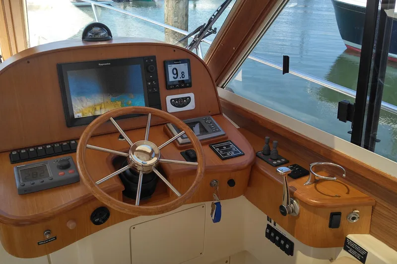 Slide: The Image of Helm of 2008 Legacy Yachts 32, featuring navigation equipment and wooden steering wheel. - 38