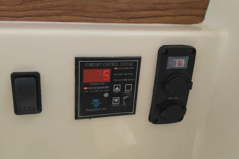 Slide: The Image of Control panel of a 2008 Legacy Yachts 32, featuring temperature and 12V DC outlets. - 47
